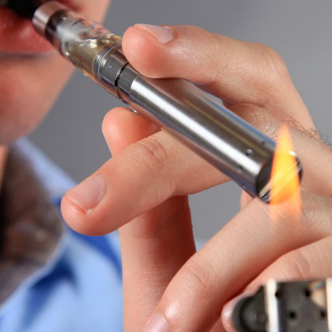 Un homme qui allume une e-cigarette avec un briquet!